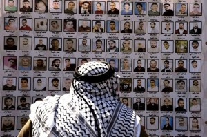 An elderly man looks at pictures of Palestinian prisoners held in Israeli jails during a protest in east Jerusalem on April 15, 2010 to demand their release ahead of Prisoner Day later this week. The Islamist Hamas movement which controls Gaza said on April 13 that it would insist on a high price in any prisoner exchange for captive Israeli soldier Gilad Shalit who was captured in a deadly cross-border raid from Gaza in June 2006. Ezzat al-Risheq, a member of the movement's politburo in exile, said in a statement that some 8,200 Palestinian prisoners remain in Israeli jails, 30 of them women and 400 of them children. AFP PHOTO/MENAHEM KAHANA (Photo credit should read MENAHEM KAHANA/AFP/Getty Images)